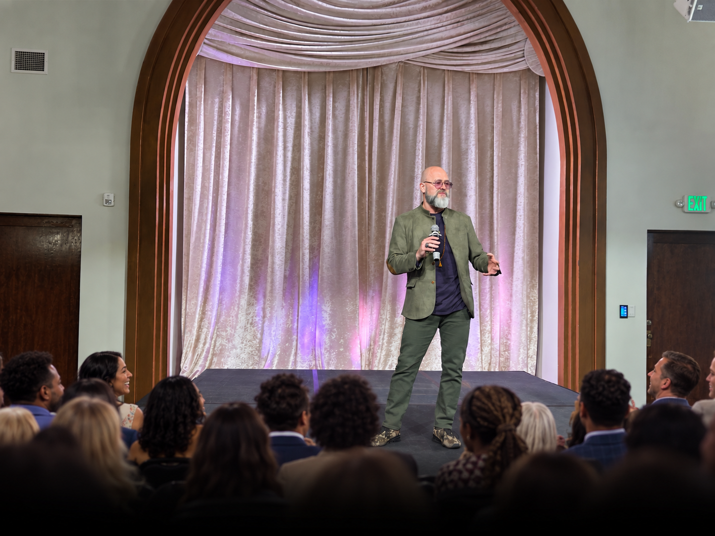 Mark A. Grainger speaking on stage to a full room