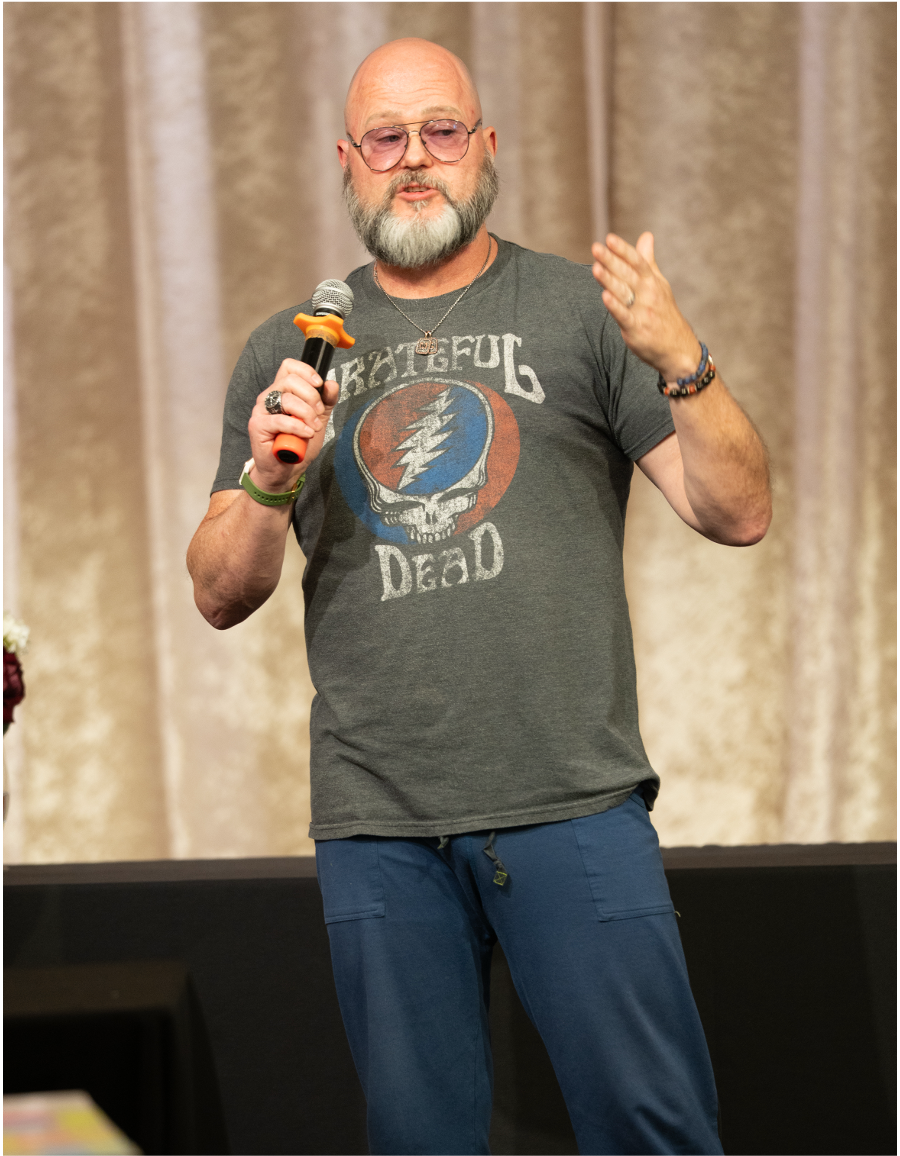 Mark A. Grainger on stage with a microphone